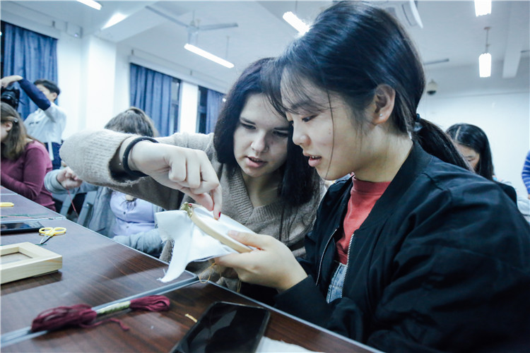 同学们与白俄罗斯交换生互相帮忙完成刺绣 刘晓敏摄.jpg