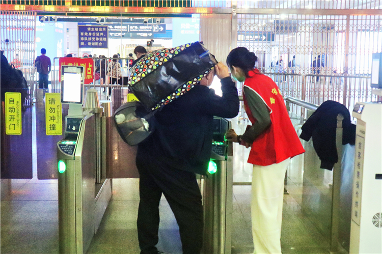 志愿者为过往乘客提供协助检票服务.jpg