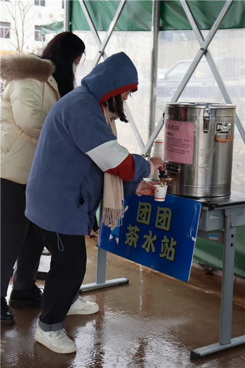 20220220绵绵春雨伴返校长途,山水学村迎协和学子 到校学生喝一杯学校贴心准备的姜茶 黄佳婷 摄.jpg