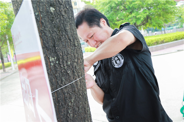 校园内的巡警在粘贴告示板 提示过往车辆 林小毳/摄