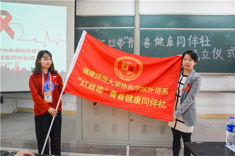 院团委副书记黄曦老师为“红丝带”青春健康同伴社授旗.JPG