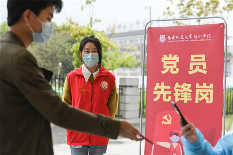 20220322志愿者陈俊兰提醒待测师生提前准备登记码 林响摄 (22).jpg